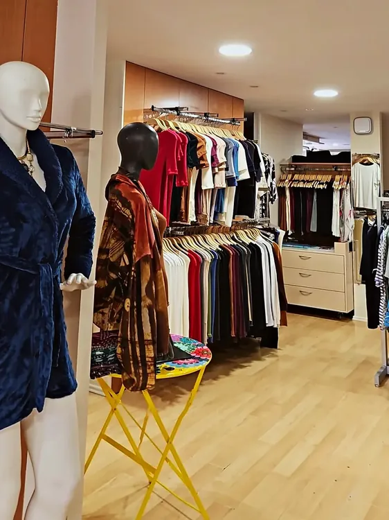 Mannequin en robe de chambre en velours bleu, portants de hauts colorés