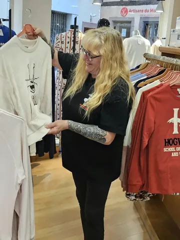 Patricia Ellinger dans sa boutique, un haut de pyjama à la main